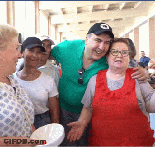 A Group Of People Are Posing For A Picture And One Of Them Is Wearing A Hat That Says ' Washington ' On It GIF