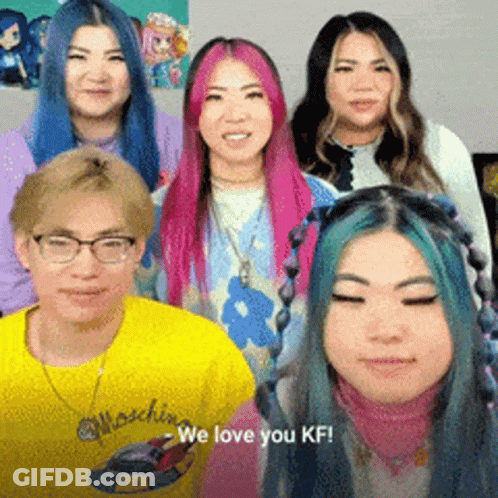 A Group Of People Are Posing For A Picture And One Of Them Is Wearing A Yellow Shirt That Says We Love You Kf GIF