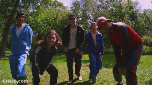 A Group Of People Are Posing For A Picture In A Grassy Field GIF