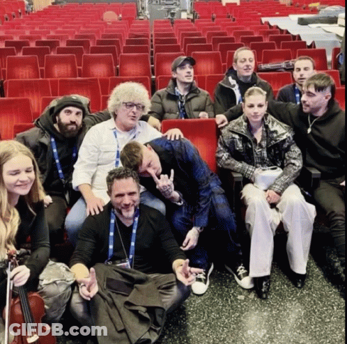 A Group Of People Are Posing For A Picture In A Theater GIF