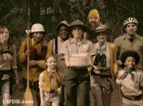 A Group Of People Are Posing For A Picture With A Woman Holding A Cake GIF