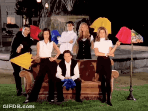 A Group Of People Are Posing For A Picture With Umbrellas In Front Of A Fountain GIF