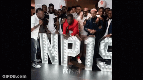A Group Of People Are Posing In Front Of A Sign That Says Nipt9 GIF