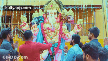 A Group Of People Are Praying In Front Of A Statue Of Ganesha . GIF