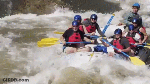 A Group Of People Are Rafting Down A River In A White Raft GIF
