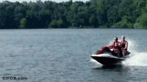 A Group Of People Are Riding A Jet Ski In The Water . GIF