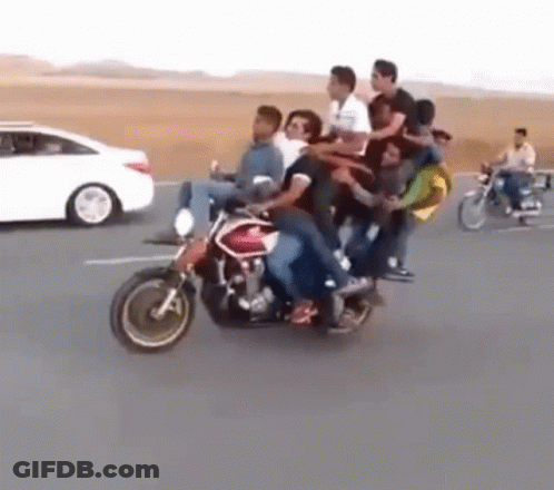 A Group Of People Are Riding A Motorcycle On The Road . GIF