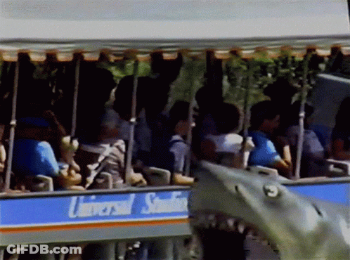 A Group Of People Are Riding A Trolley That Says Universal Studios GIF