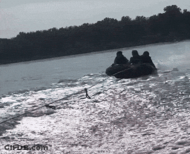 A Group Of People Are Riding A Tube On A Lake GIF