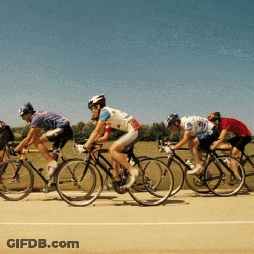 A Group Of People Are Riding Bikes On A Track GIF
