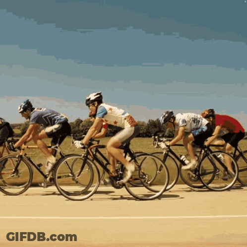 A Group Of People Are Riding Bikes On A Track GIF