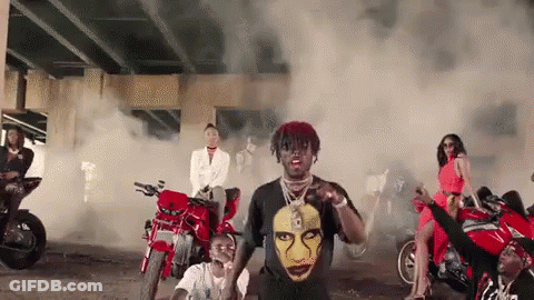 A Group Of People Are Riding Motorcycles Under A Bridge And Smoke Is Coming Out Of The Motorcycles . GIF