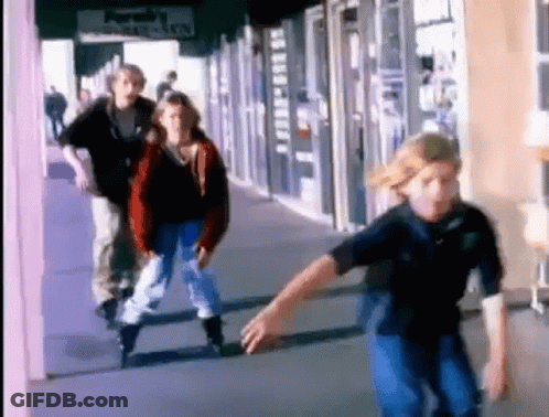 A Group Of People Are Rollerblading Down A Sidewalk In Front Of A Store That Says ' Purah 'S ' On It GIF
