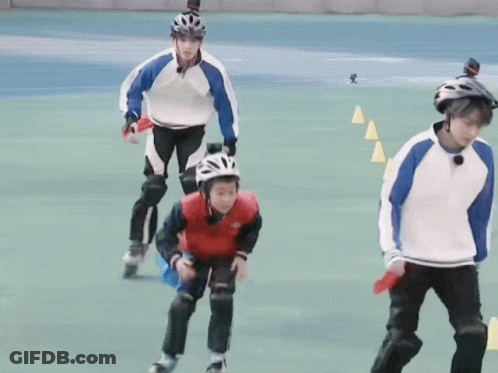 A Group Of People Are Rollerblading On A Field And One Of Them Is Wearing A Helmet GIF
