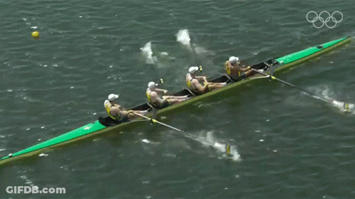A Group Of People Are Rowing A Boat In The Water GIF