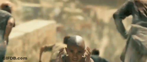 A Group Of People Are Running In The Desert And A Man Is Screaming . GIF
