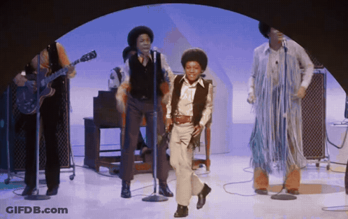 A Group Of People Are Singing And Dancing On Stage GIF