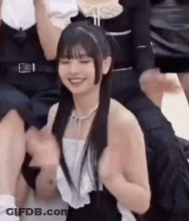 A Group Of People Are Sitting Around A Girl . GIF