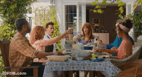 A Group Of People Are Sitting Around A Table Eating Food And Drinking Wine GIF