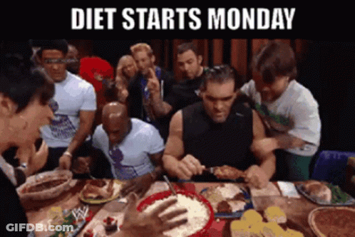 A Group Of People Are Sitting Around A Table Eating Food With The Words Diet Starts Monday Above Them GIF