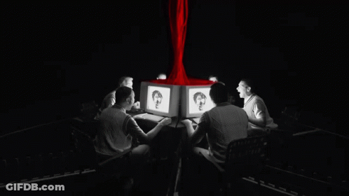 A Group Of People Are Sitting Around A Table Looking At Computers GIF