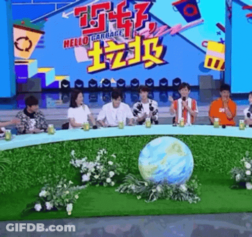 A Group Of People Are Sitting Around A Table With A Globe In The Middle Of The Table . GIF
