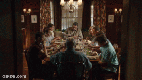 A Group Of People Are Sitting At A Table Eating Food GIF