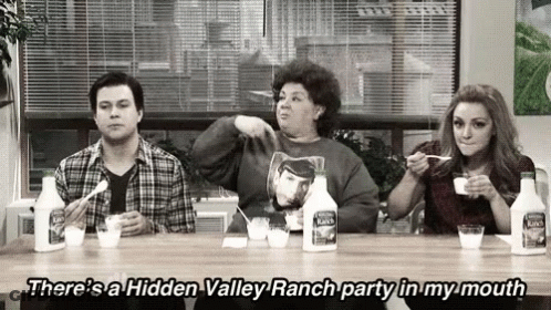 A Group Of People Are Sitting At A Table Eating Ranch GIF