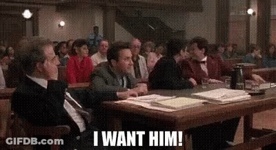 A Group Of People Are Sitting At A Table In A Courtroom And One Of Them Is Saying `` I Want Him ! '' GIF