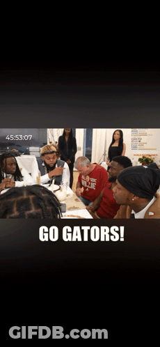 A Group Of People Are Sitting At A Table With The Words Go Gators On The Bottom GIF