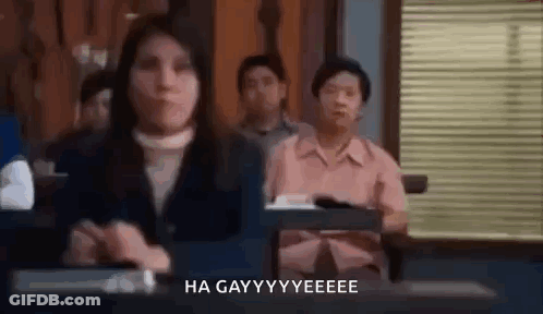 A Group Of People Are Sitting At Desks In A Classroom . GIF