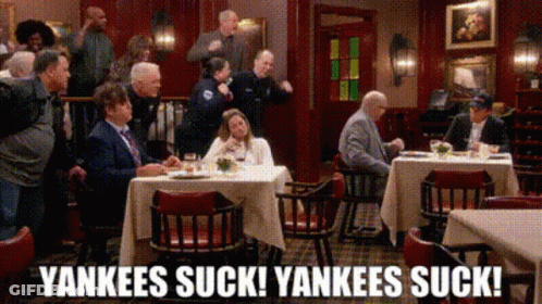 A Group Of People Are Sitting At Tables In A Restaurant With The Words Yankees Suck Yankees Suck Written On The Bottom GIF