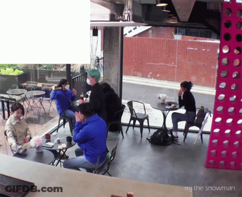 A Group Of People Are Sitting At Tables In A Room With The Words " Mr. The Snowman " At The Bottom GIF