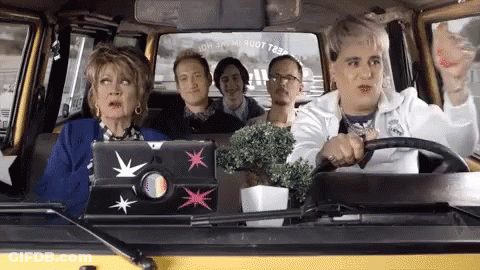 A Group Of People Are Sitting In A Car And One Of Them Has A Laptop On The Back Seat GIF