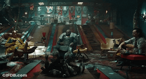 A Group Of People Are Sitting In A Room With A Bowling Alley And A Sign That Says S GIF