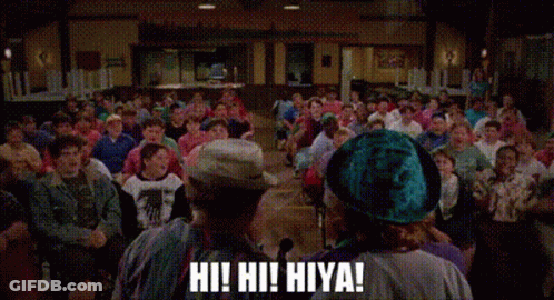 A Group Of People Are Sitting In A Room With Their Arms In The Air And One Of Them Is Shouting . GIF