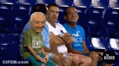 A Group Of People Are Sitting In A Stadium And One Of Them Is Wearing A Hollister Shirt . GIF