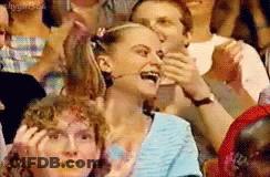 A Group Of People Are Sitting In A Stadium And One Woman Is Laughing GIF