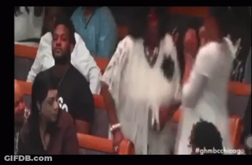 A Group Of People Are Sitting In A Stadium Watching A Game And Talking To Each Other . GIF
