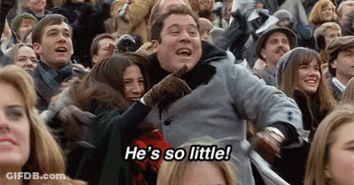 A Group Of People Are Sitting In A Stadium Watching A Game . GIF
