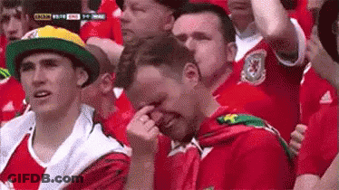 A Group Of People Are Sitting In A Stadium Watching A Soccer Game . GIF