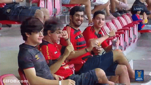 A Group Of People Are Sitting In A Stadium With A Live Fc Logo On The Bottom GIF