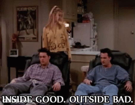 A Group Of People Are Sitting In Chairs In A Living Room With A Woman Standing In The Background . GIF