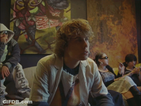 A Group Of People Are Sitting In Front Of A Painting And One Of Them Is Wearing A Jacket That Says Ash On The Bottom GIF