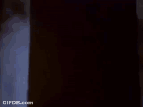A Group Of People Are Sitting In Front Of A Projector Screen Watching A Cartoon . GIF