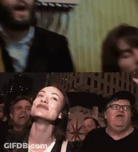 A Group Of People Are Sitting In Front Of A Sign That Says " Hollywood " GIF