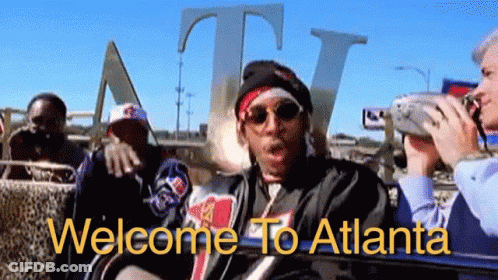 A Group Of People Are Sitting In Front Of A Sign That Says Welcome To Atlanta On It GIF