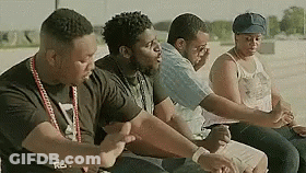 A Group Of People Are Sitting Next To Each Other In A Row . GIF