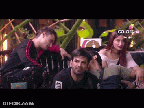 A Group Of People Are Sitting On A Bench With A Sign That Says Colors Hd On It GIF