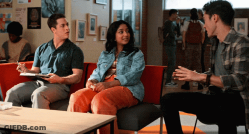 A Group Of People Are Sitting On A Couch In A Hallway GIF